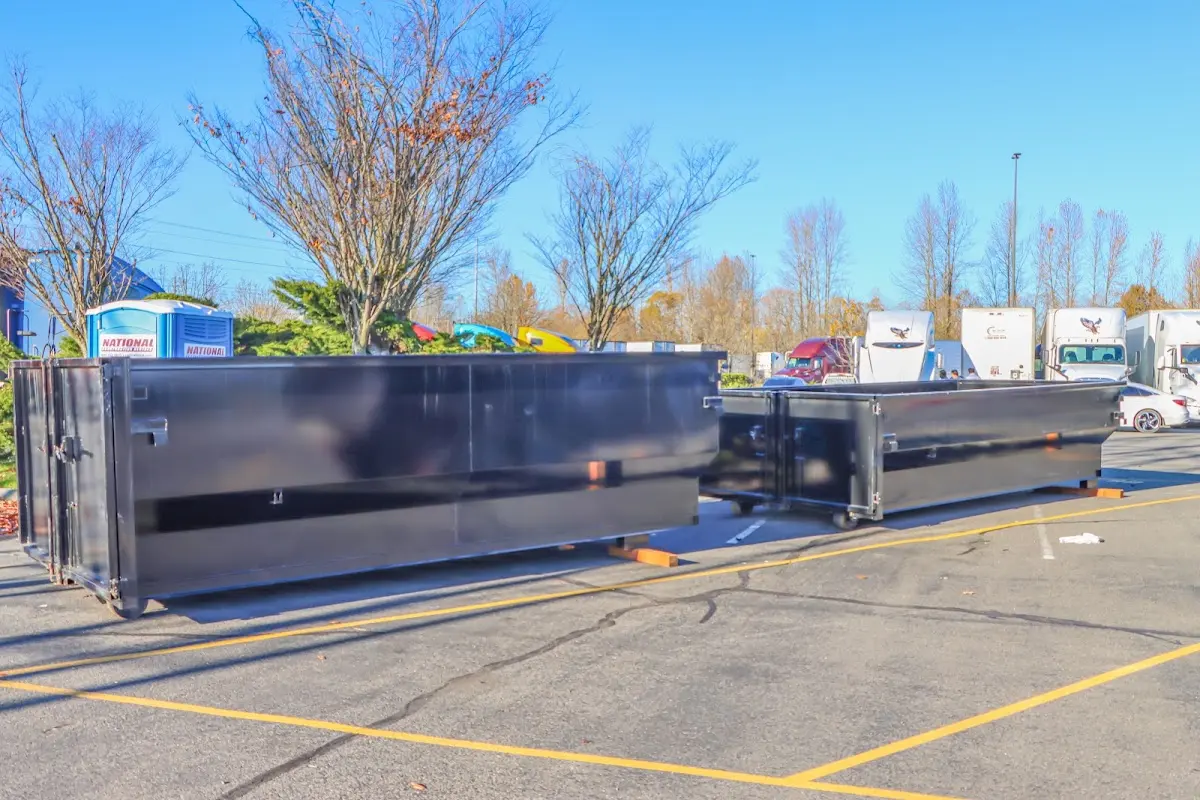 Professional dumpster rental service with roll-off container on residential driveway in Brownsville